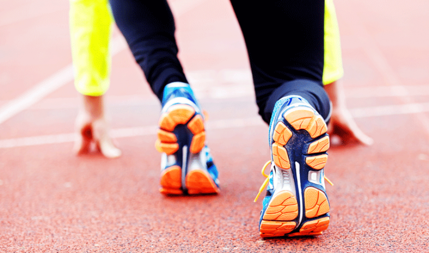 person on running track getting ready to run